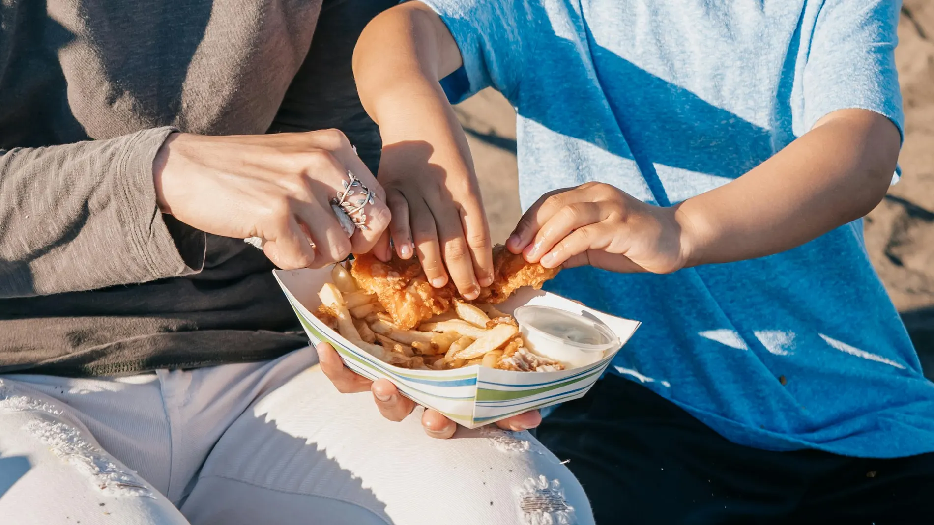 Un niño comiendo junto a su madre