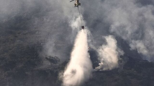 Un helicóptero trabaja en las labores de extinción del incendio que afectó a la Sierra de la Plata, en Tarifa (Cádiz)