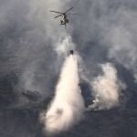 Un helicóptero trabaja en las labores de extinción del incendio que afectó a la Sierra de la Plata, en Tarifa (Cádiz)