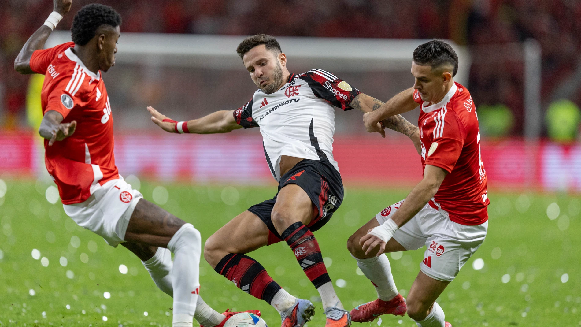 Saul Niguez of Brazil's Flamengo, center, is challenged by Vitao, left, and Rafael Borre of Brazil's Internacional during a Copa Libertadores round of sixteen second leg soccer match at Beira Rio stadium in Porto Alegre, Brazil, Wednesday, Aug. 20, 2025. (AP Photo/Liamara Polli)