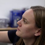 Jessica Barnes examina un vial que contiene partículas de muestra en el Laboratorio Kuiper-Arizona de Análisis de Astromateriales, ubicado en la Universidad de Arizona.