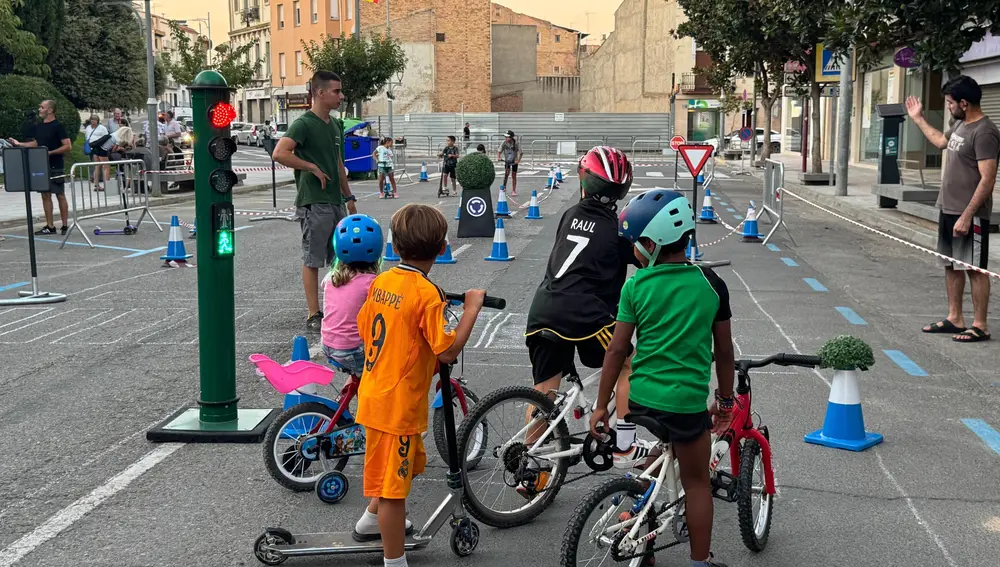 Varios niños en el circuito vial preparado en el centro de Binéfar en el segundo fin de semana de la movilidad sostenible.