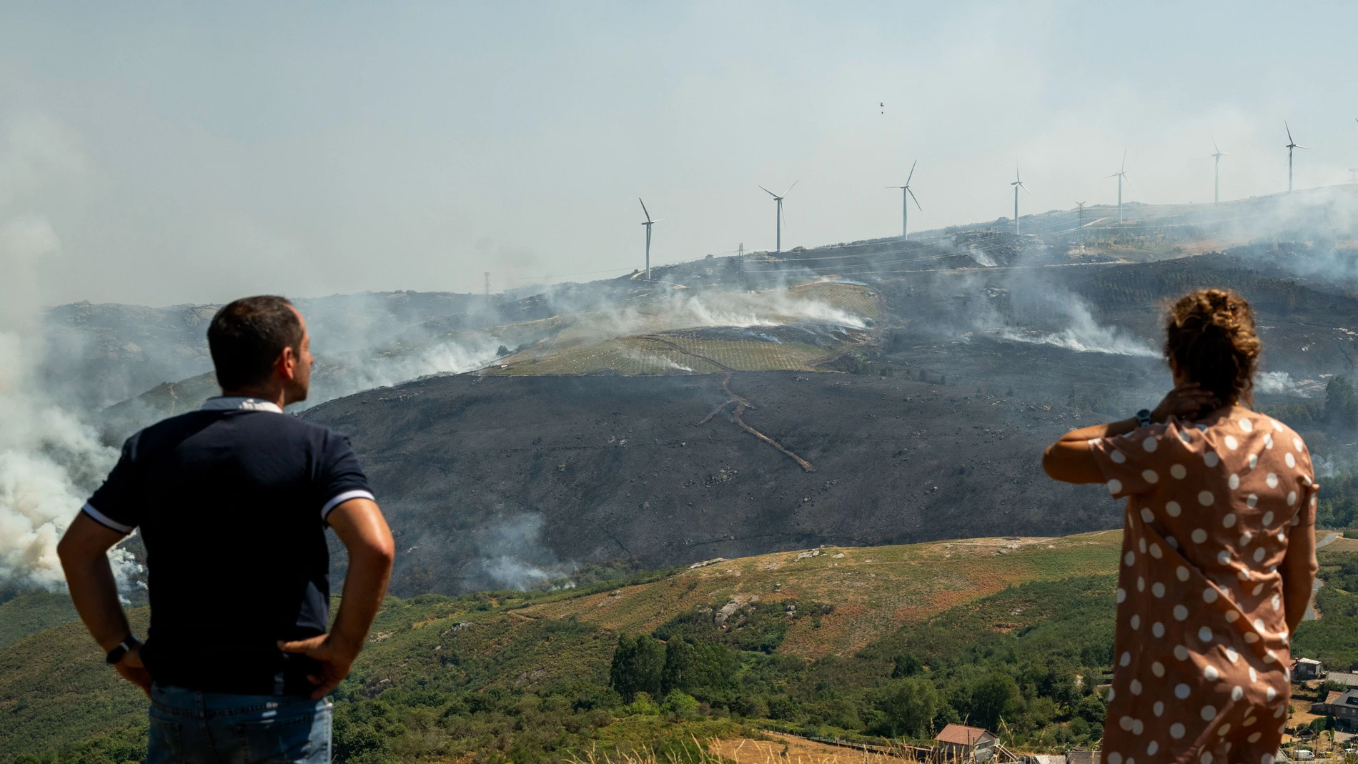 AVIÓN (OURENSE), 25/08/2025.- Varias personas observan el incendio forestal declarado ayer en Avión (Ourense), este lunes. EFE/Brais Lorenzo