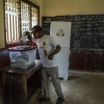 Un votante deposita su voto en un colegio electoral en Conakry