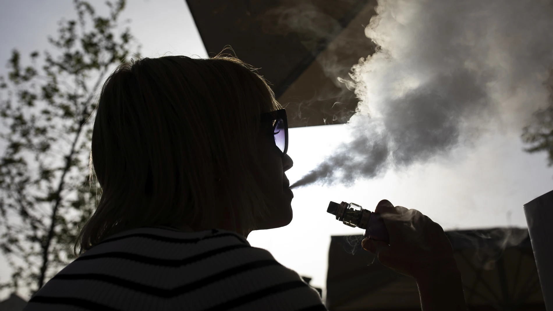 Una mujer usando una alternativa a los cigarrillos de combustión tradicionales