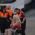 Agentes de Protección Civil ayudan a una mujer afectada por los incendios en Zamora
