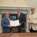 El alcalde de Segovia, José Mazarías, suscribe el convenio con el presidente de la Asociación de Periodistas de Segovia, Miguel Ángel López, en presencia del concejal Juan Carlos Monroy