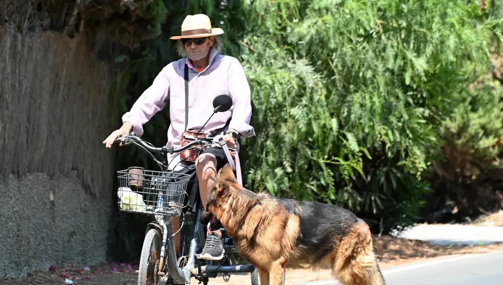 Amador Mohedano paseando en bici con su perro