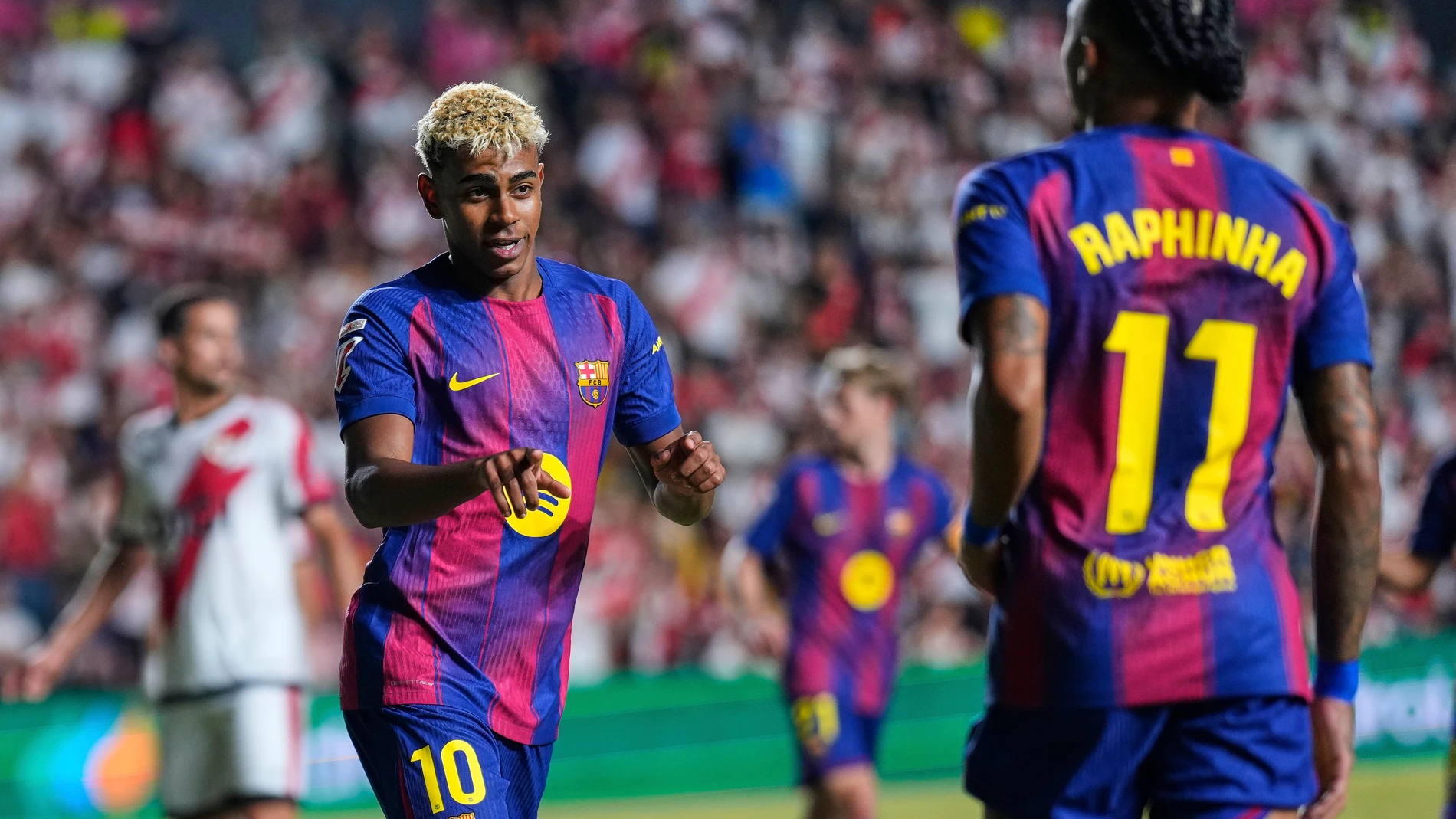 Barcelona's Lamine Yamal, left, celebrates with Raphinha after scoring the opening goal from the penalty spot during the Spanish La Liga soccer match between Rayo Vallecano and FC Barcelona at the Vallecas stadium in Madrid, Spain, Sunday, Aug. 31, 2025. (AP Photo/Manu Fernandez)