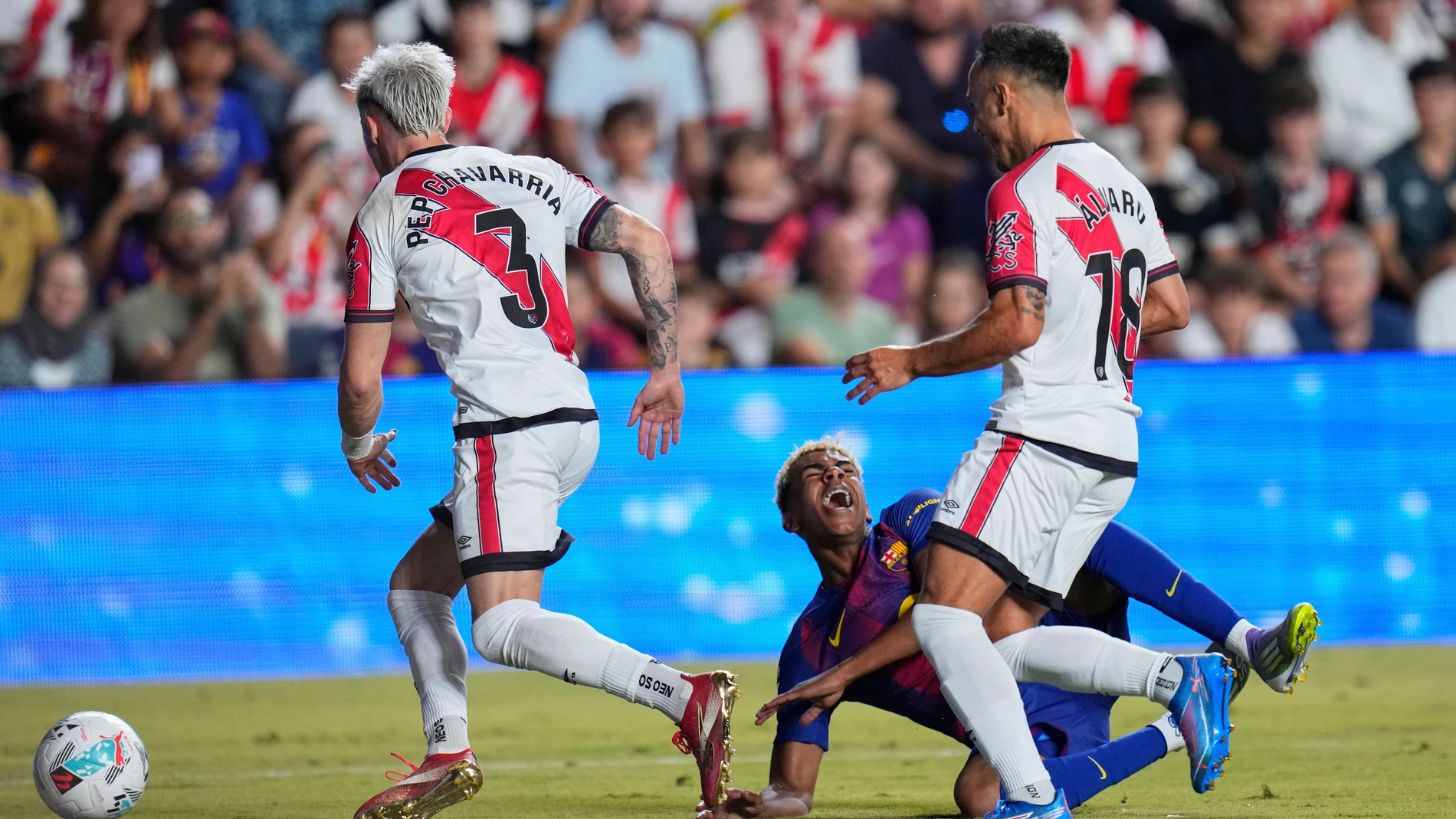 Barcelona's Lamine Yamal, center, is fouled to concede a penalty during the Spanish La Liga soccer match between Rayo Vallecano and FC Barcelona at the Vallecas stadium in Madrid, Spain, Sunday, Aug. 31, 2025. (AP Photo/Manu Fernandez)