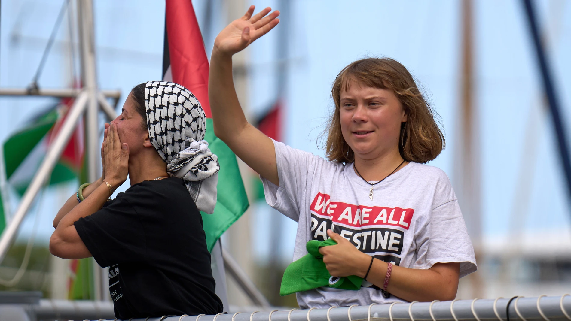 Swedish climate activist Greta Thunberg waves from a boat taking part in a civilian flotilla bound for Gaza, aiming to break the Israeli blockade and deliver humanitarian aid, in Barcelona, Spain, Sunday, Aug. 31, 2025. (AP Photo/Emilio Morenatti)