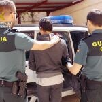 Uno de los detenidos es custodiado por dos agentes de la Guardia Civil