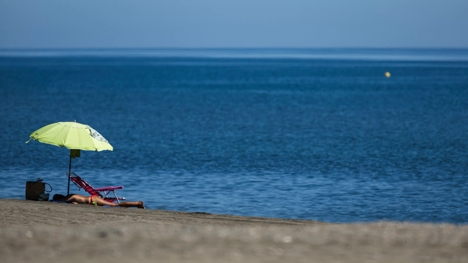 Varias personas disfrutan del buen tiempo en la playa de El Rincón de la Victoria (Málaga)