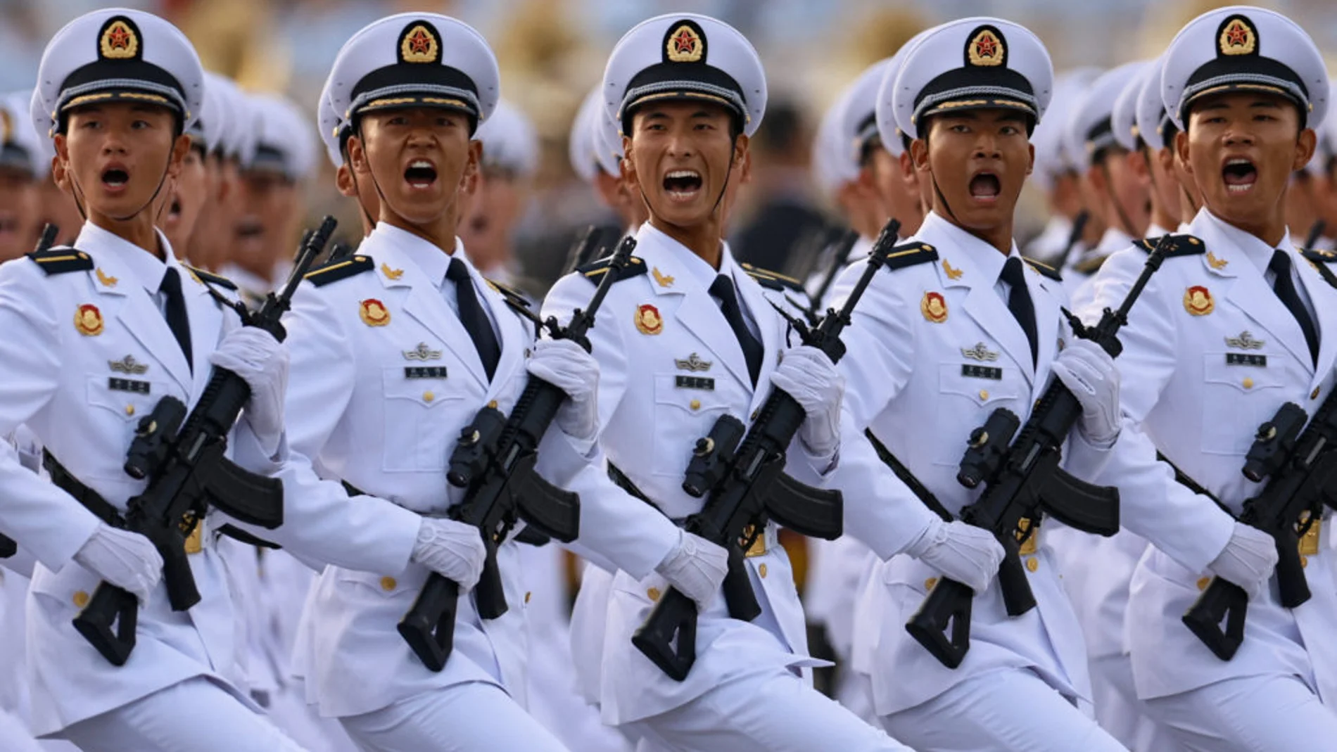Soldados chinos con uniforme blanco y armas de asalto durante el desfile
