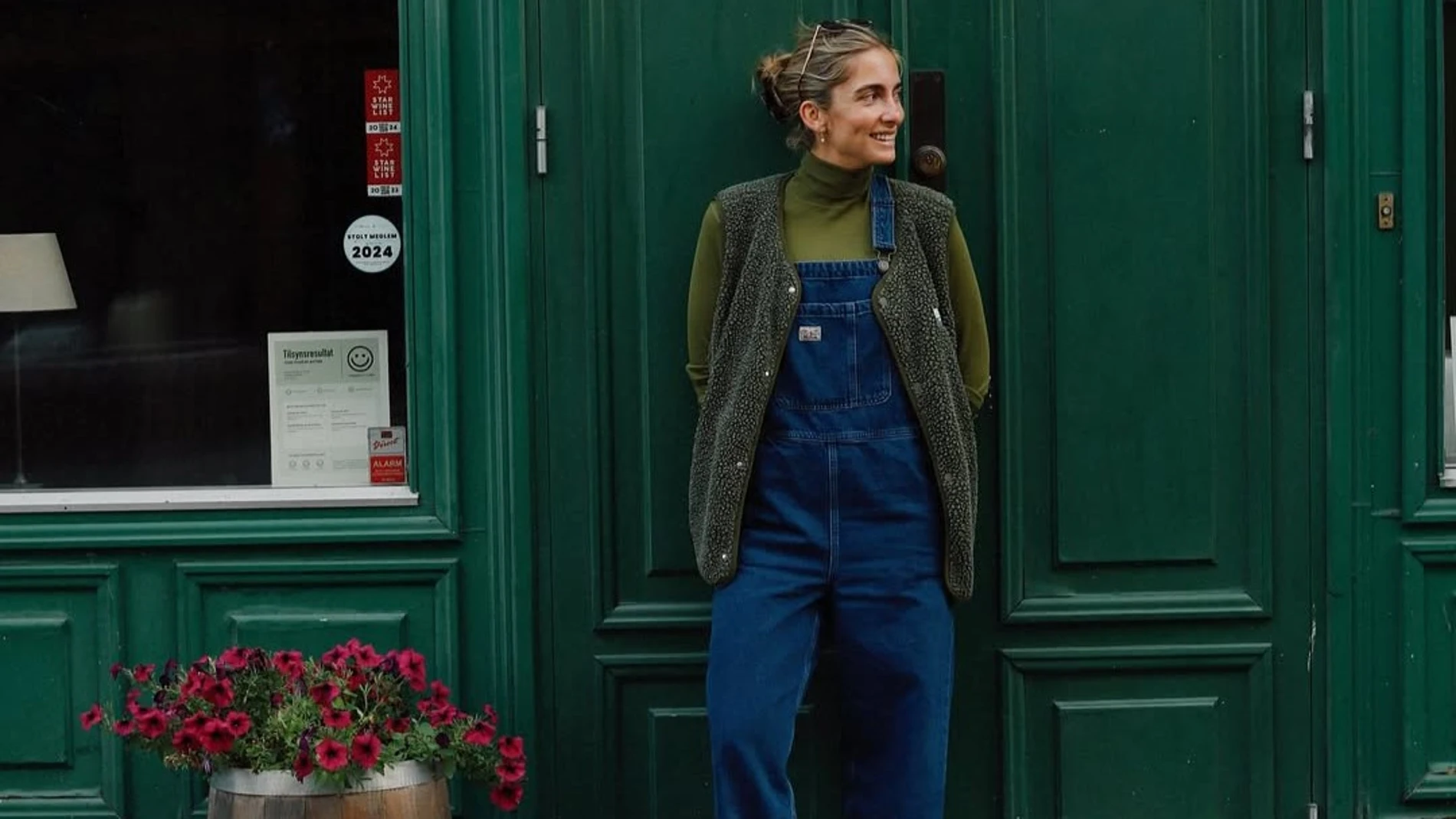Influencer con chaleco polar verde y peto vaquero en un look urbano de entretiempo