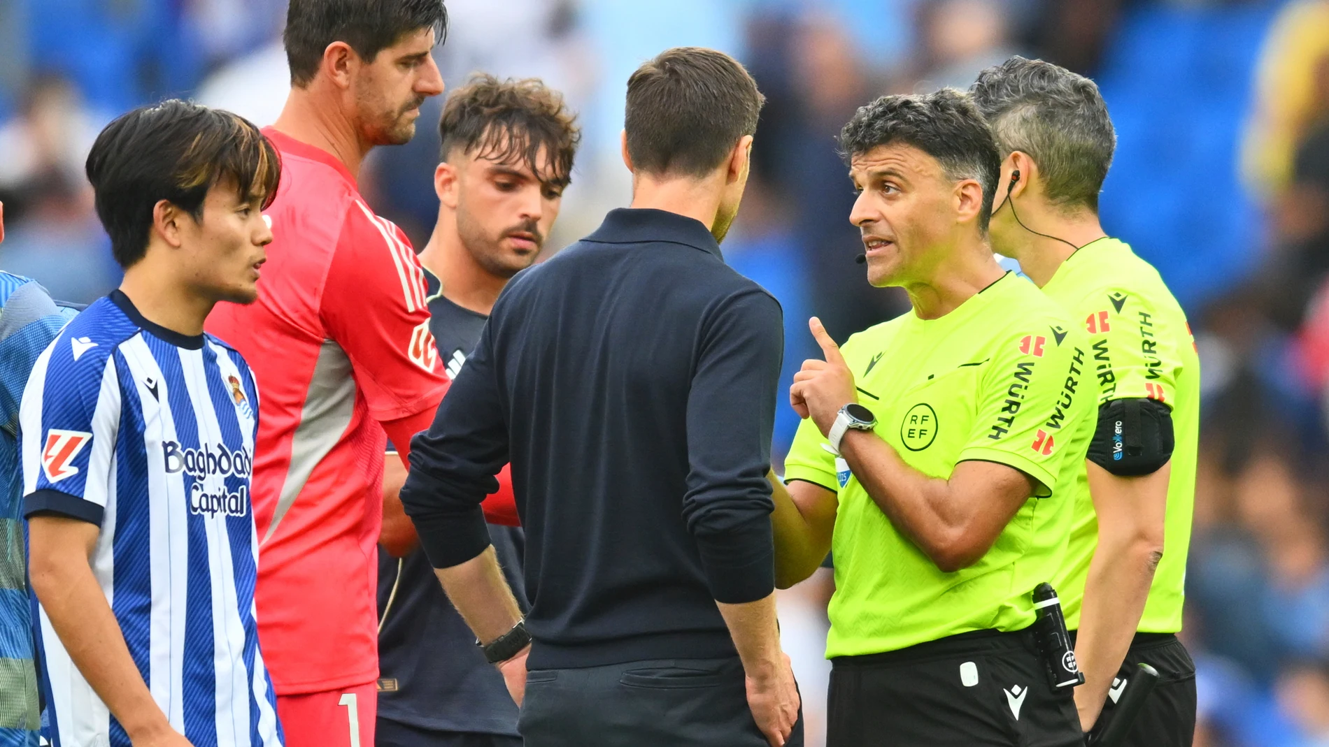 Real Madrid's head coach Xabi Alonso, centre, talks with referee Jesus Gil Manzano during the La Liga soccer match between Real Sociedad and Real Madrid at the Reale Arena in San Sebastian, Spain, Saturday, Sept. 13, 2025. (AP Photo/Miguel Oses)