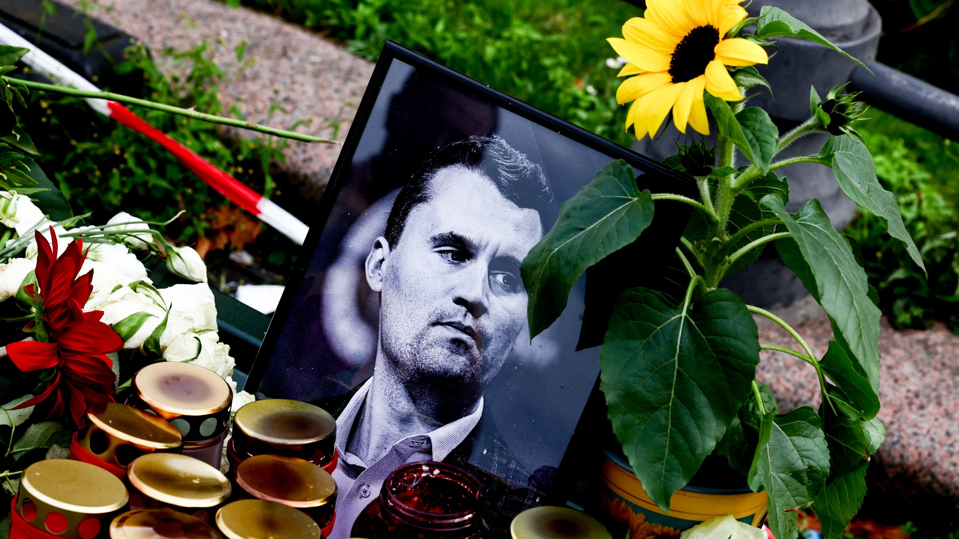 BERLIN (Germany), 13/09/2025.- Flowers and candles are placed in front of a photo of the slain US political activist Charlie Kirk during a vigil in reaction to his assassination, in Berlin, Germany, 13 September 2025. Kirk was fatally shot on 10 September at an event at Utah Valley University. The vigil was held near the Brandenburg Gate in front of the US embassy. (Alemania) EFE/EPA/FILIP SINGER