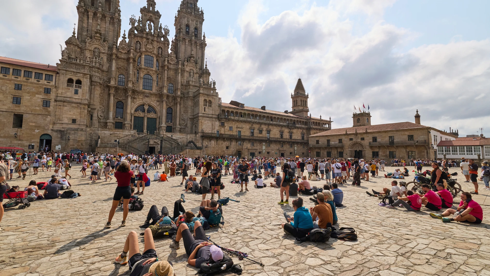 Pilgrims and tourists rest in front of the cathedral in Santiago de Compostela, northwestern Spain, Thursday, Aug. 21, 2025. (AP Photo/Lalo Villar)