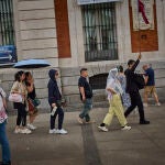 Turistas en plena ola de calor en agosto en la ciudad de Madrid intentan refrescarse en las fuentes de agua in