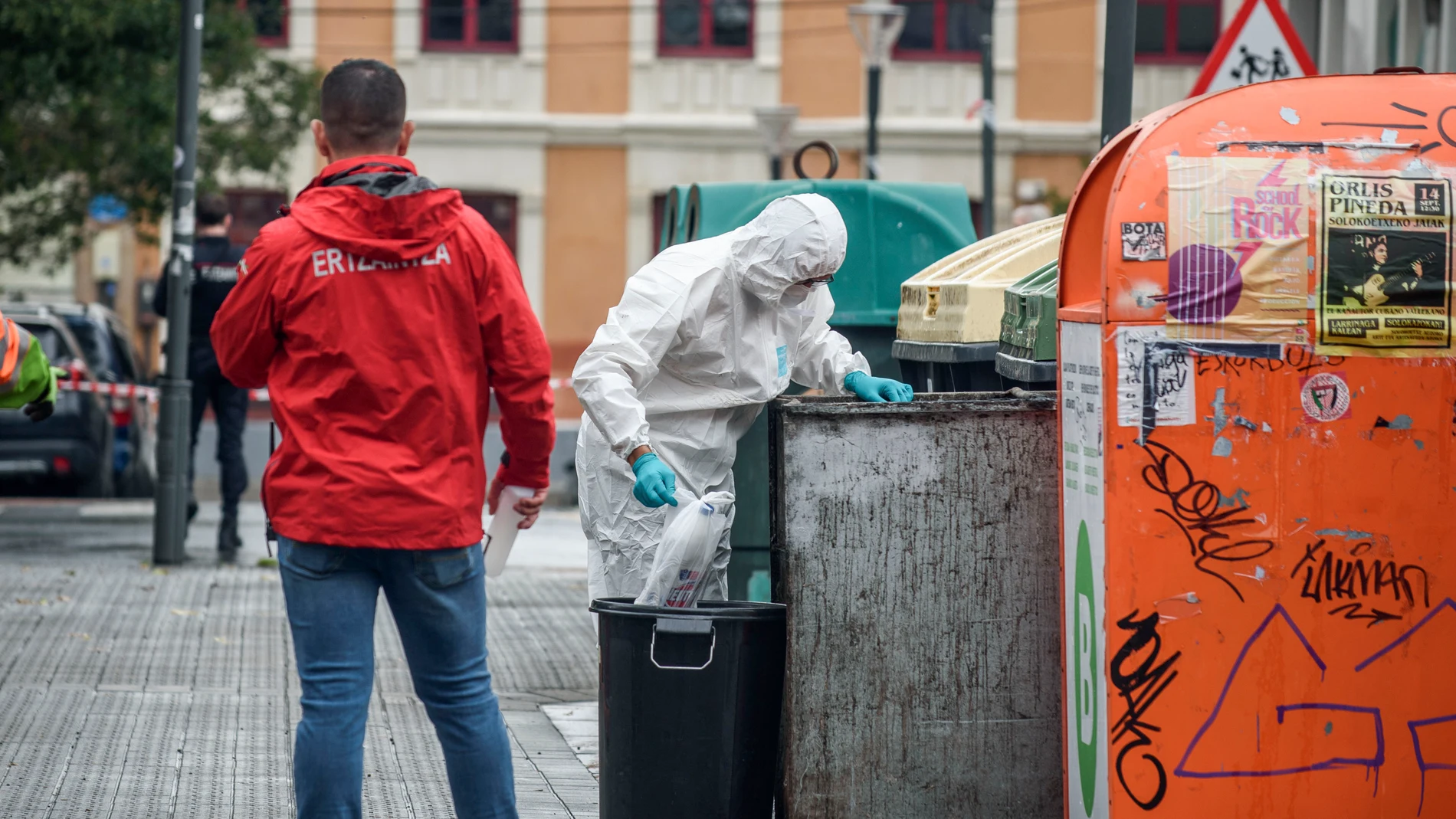 BILBAO (PAÍS VASCO), 21/09/2025.- La Ertzaintza inspecciona unos contenedores cercanos al portal número 7 de la calle Zumarraga de Bilbao, en las investigaciones del fallecimiento de un hombre este domingo en Bilbao tras sufrir heridas de arma blanca en el pecho en el transcurso de un altercado. EFE/Javier Zorrilla