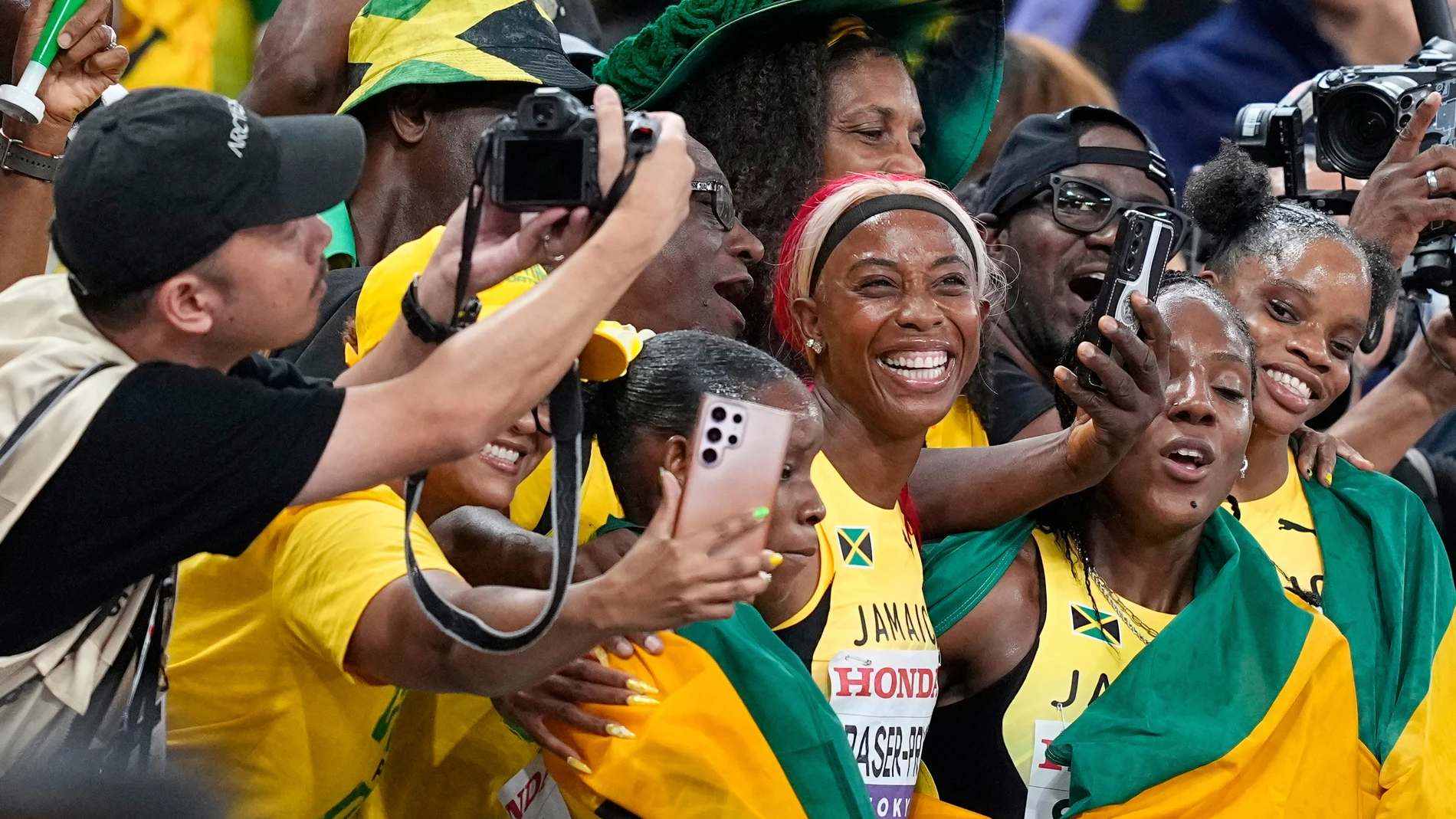 Jamaica's Shelly-Ann Fraser-Pryce and her teammates celebrate with supporters after taking the silver in the women's 4 X 100 meters relay final at the World Athletics Championships in Tokyo, Sunday, Sept. 21, 2025. (AP Photo/Petr David Josek)