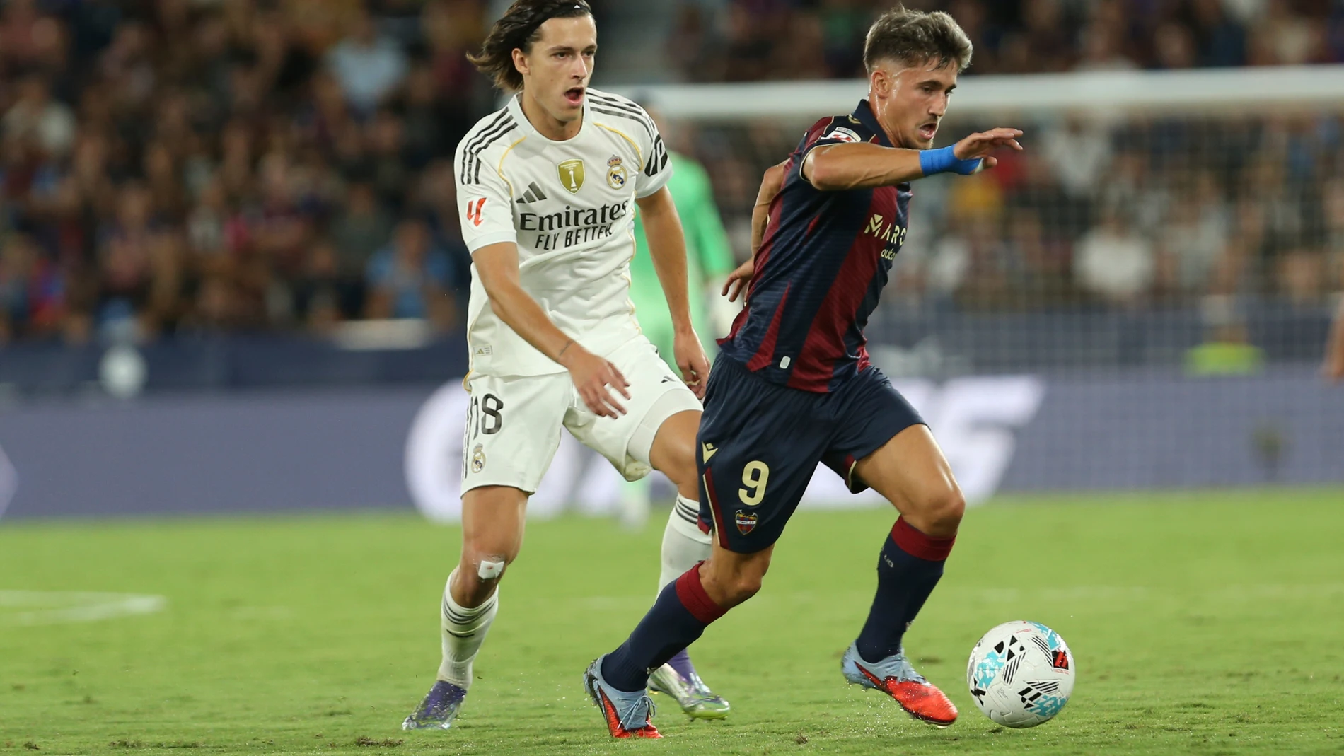 Levantes' Ivan Romero, runs with the ball ahead Real Madrid's Alvaro Carreras during a Spanish La Liga soccer match between Levante and Real Madrid at the Ciutat de Valencia stadium in Valencia, Spain, Tuesday, Sept. 23, 2025. (AP Photo/Alberto Saiz)