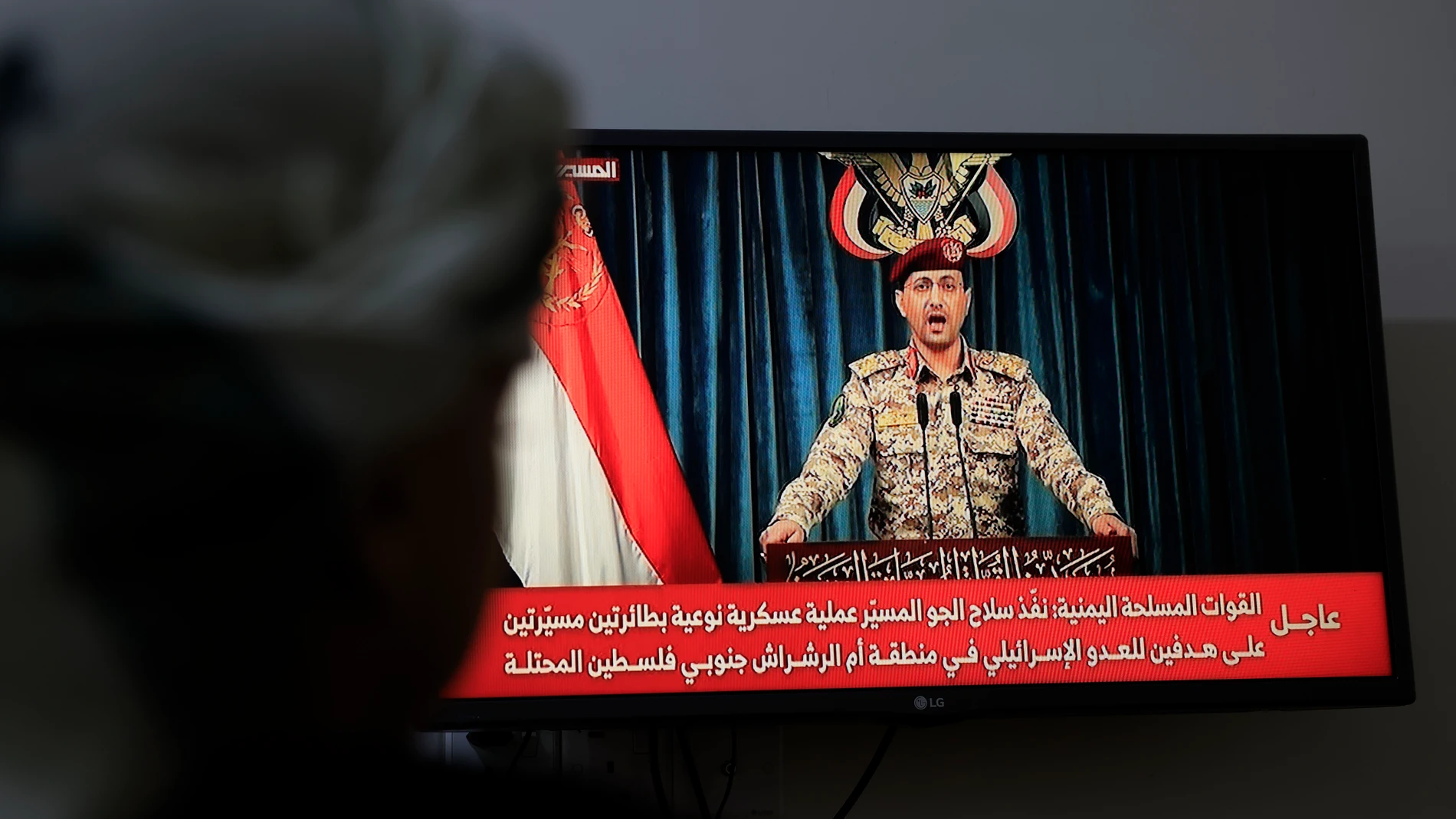 SANA'A (Yemen), 24/09/2025.- A person watches Houthi military spokesman Yahya Sarea delivering a televised statement in Sana'a, Yemen, 24 September 2025. Yemen's Houthis have claimed responsibility for a two-drone attack on the Israeli port city of Eilat, according to a statement by Houthi military spokesman Yahya Sarea. EFE/EPA/YAHYA ARHAB