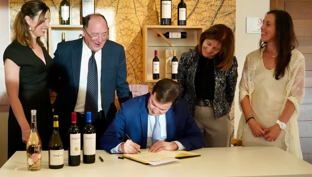 Mañueco firma en el libro de honor de la bodega junto a Carlos Moro y Paloma Moro