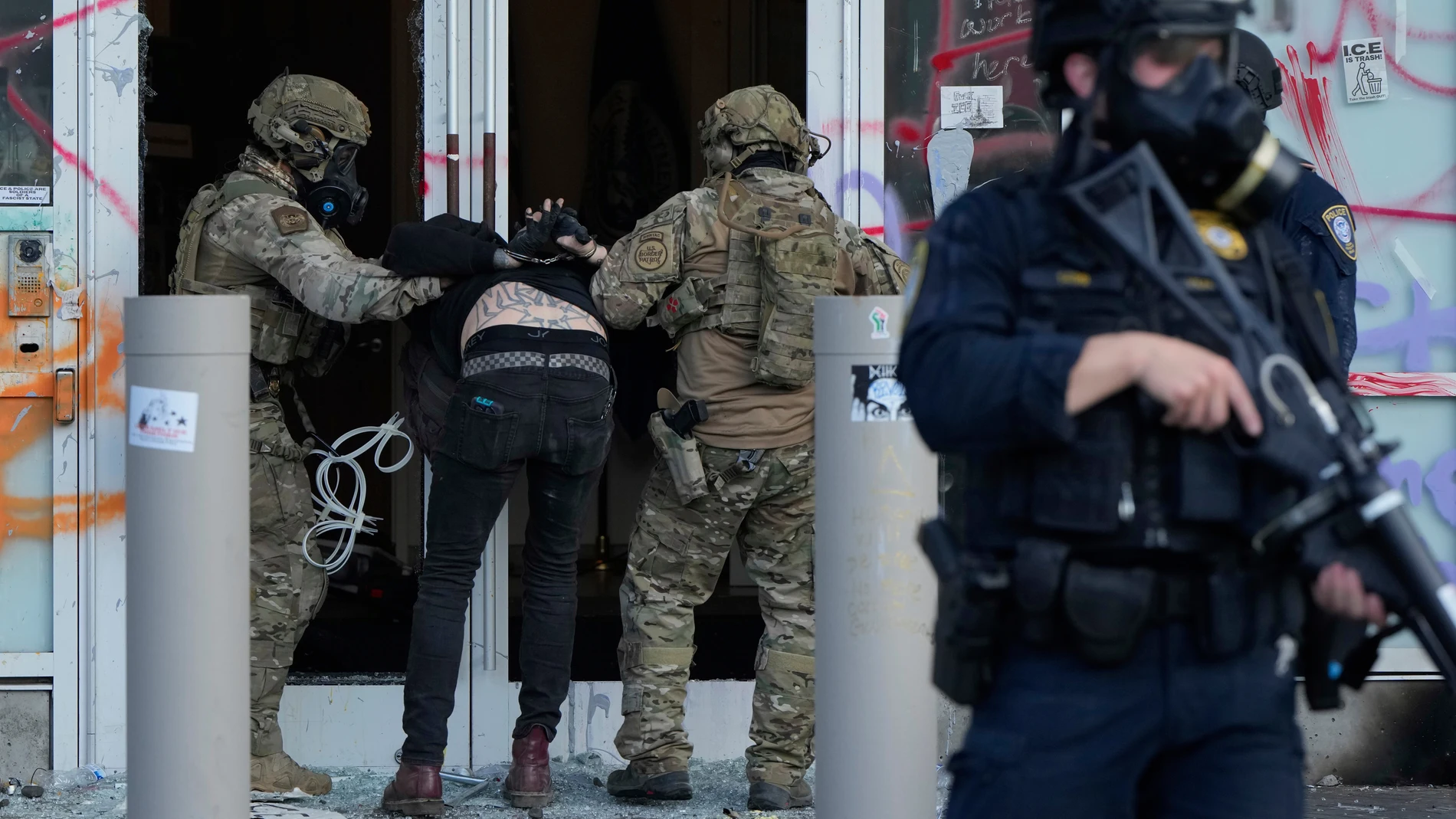 FILE - U.S. Customs and Border Protection agents detain a man outside the U.S. Immigration and Customs building during a protest in Portland, Ore., June 14, 2025. (AP Photo/Jenny Kane, File)