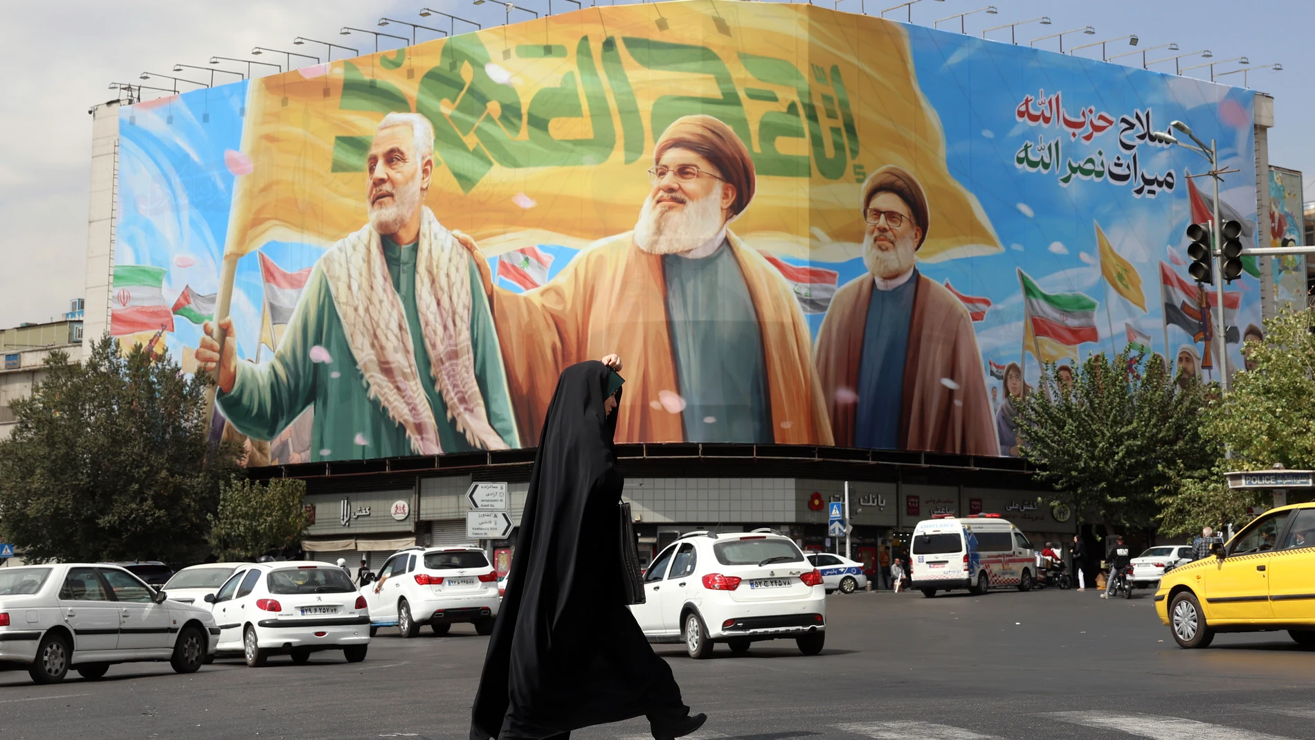 TEHRAN (IRAN(Islamic Republic Of)), 27/09/2025.- A veiled woman walks past a billboard depicting Hezbollah’s former leaders Hassan Nasrallah (C), Sheikh Safieddin (R) and late Iranian commander Qasem Soleimani (L), in Tehran, Iran, 27 September 2025. Iran has recalled its envoys to Britain, France and Germany for consultations, according to state media, after the three European countries reported Iran before the UN Security Council, leading to the re-imposition of sanctions over the alleged f...