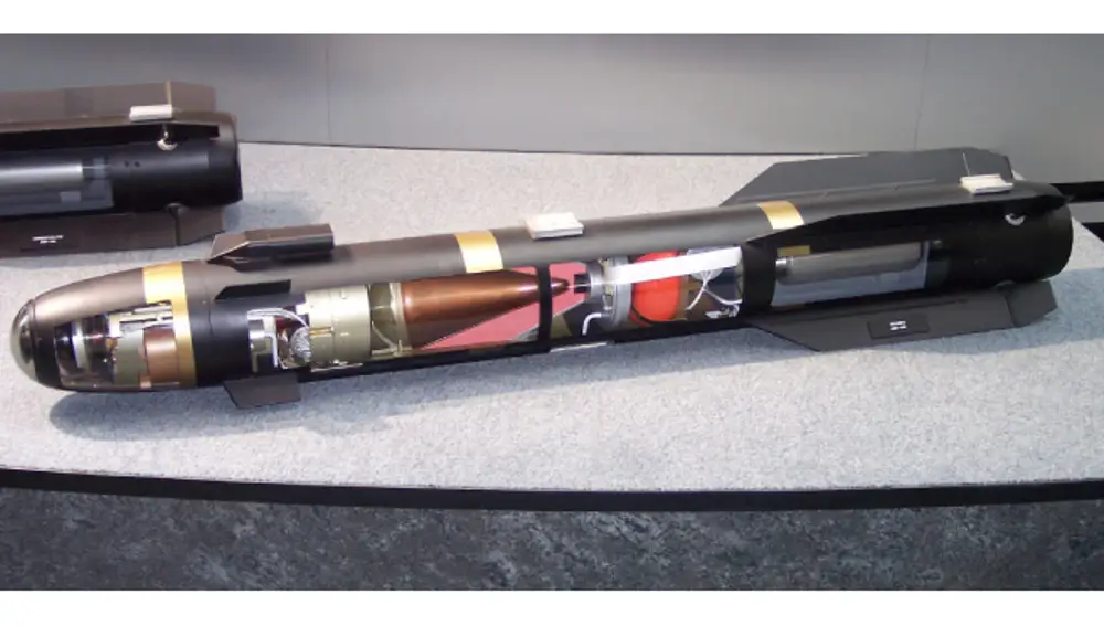 Modelo de un misil AGM-114R Hellfire II que muestra el sistema de guía láser en la parte delantera, la carga explosiva con forma de cono en el centro y la propulsión en la trasera.