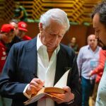 Mario Vargas Llosa firmando ejemplares