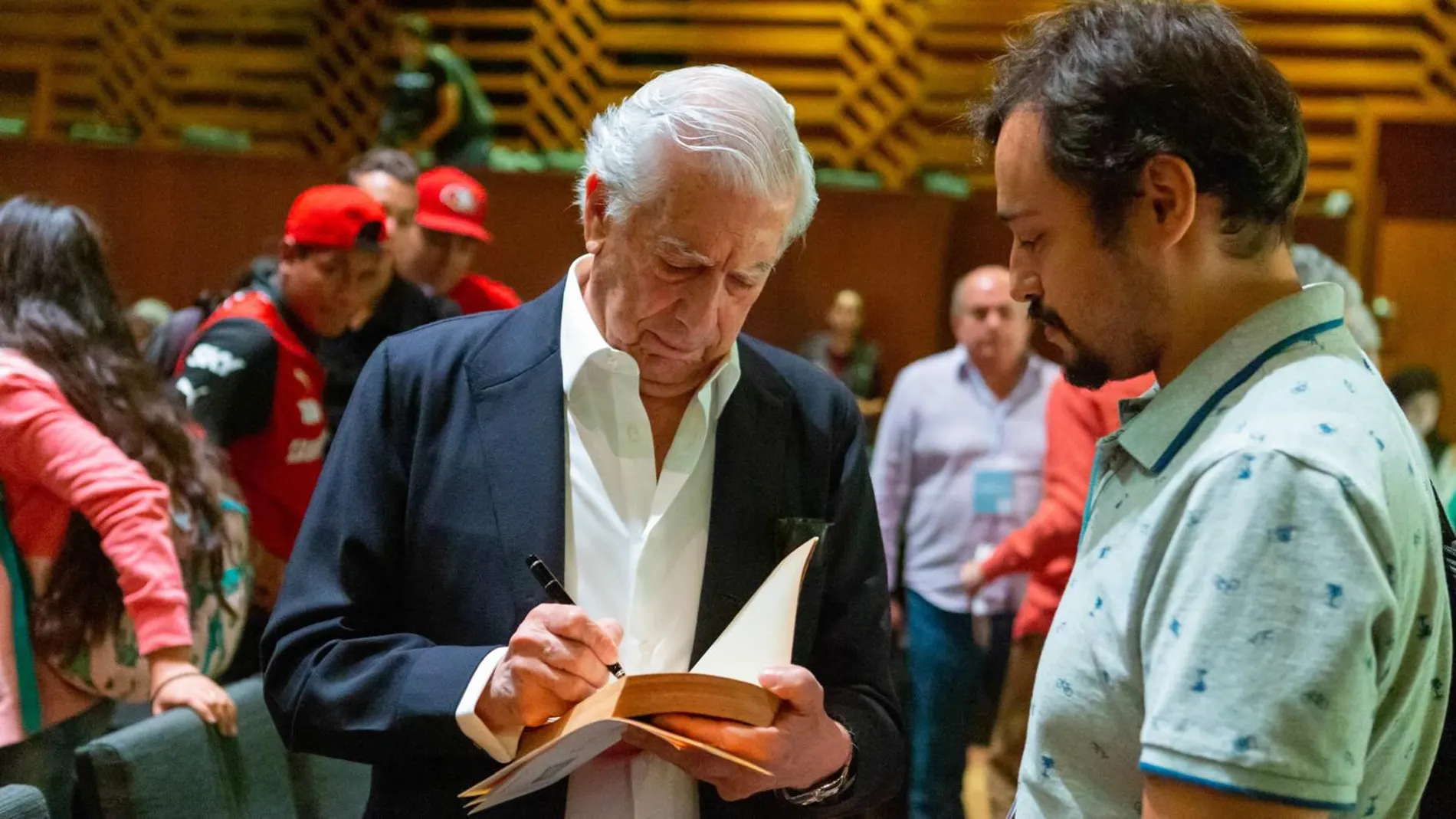 Mario Vargas Llosa firmando ejemplares
