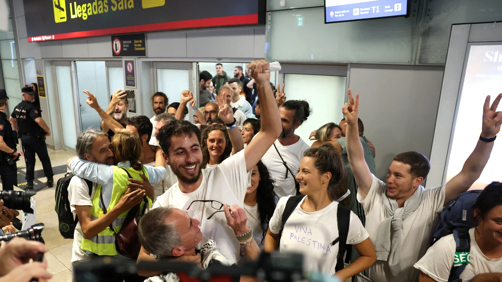 Spanish activists (white shirts) who were sailing aboard vessels from the Global Sumud Flotilla celebrate as they arrive at Madrid-Barajas Airport on October 5, 2025, after Israel stopped the Gaza-bound aid flotilla and detained hundreds of people. Spain said 21 of 49 citizens detained on a Gaza aid flotilla were due to leave Israel for home on October 5, 2025.