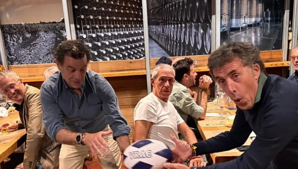 Pedro Delgado y Óscar Garrote, propietario del Vinotinto, jueganon un balón de rugby en el interior del restaurante