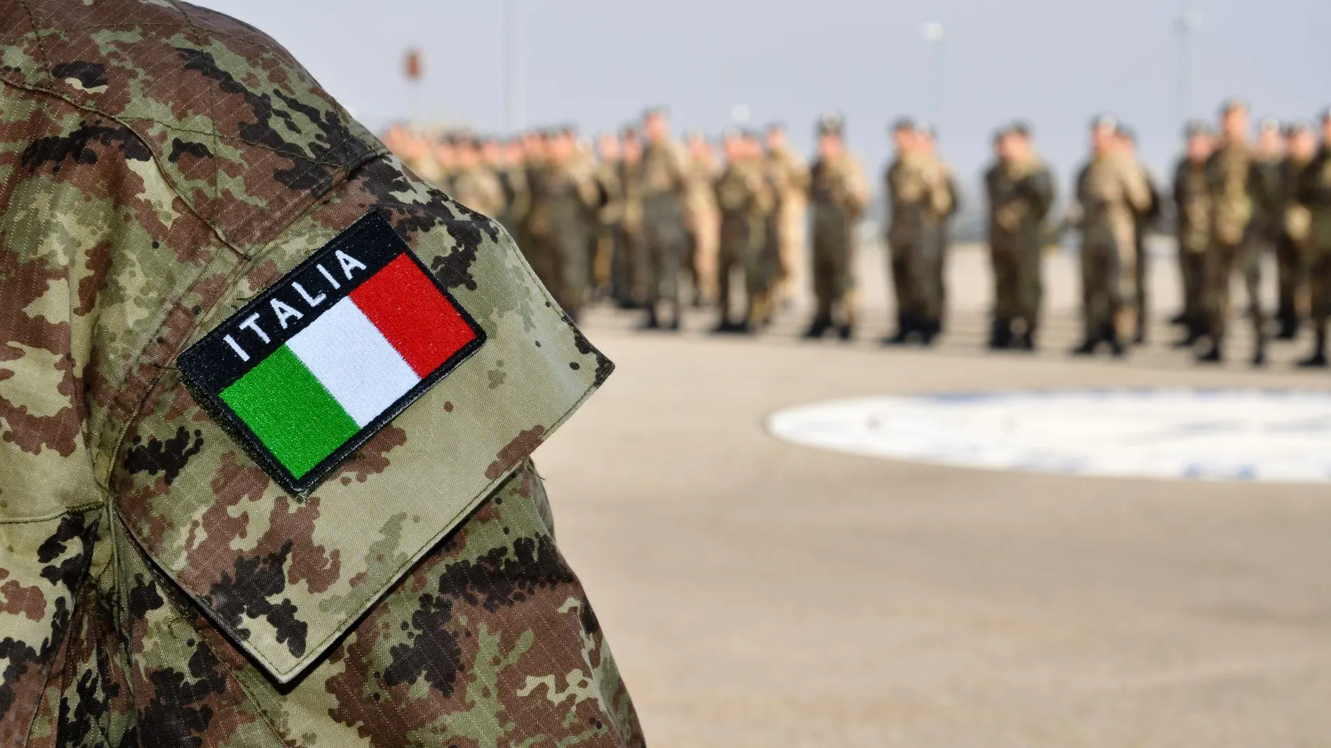 Parche militar sobre una guerrera de camuflaje en la que aparece la bandera de Italia