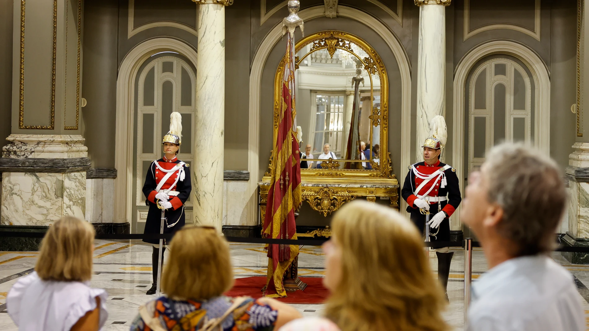 GRAFCVA9692. VALENCIA, 08/10/2025.- Varias personas contemplan la Real Senyera expuesta en el Salón de Cristal del ayuntamiento con motivo de la exposición “La Nostra Senyera”. EFE/Ana Escobar