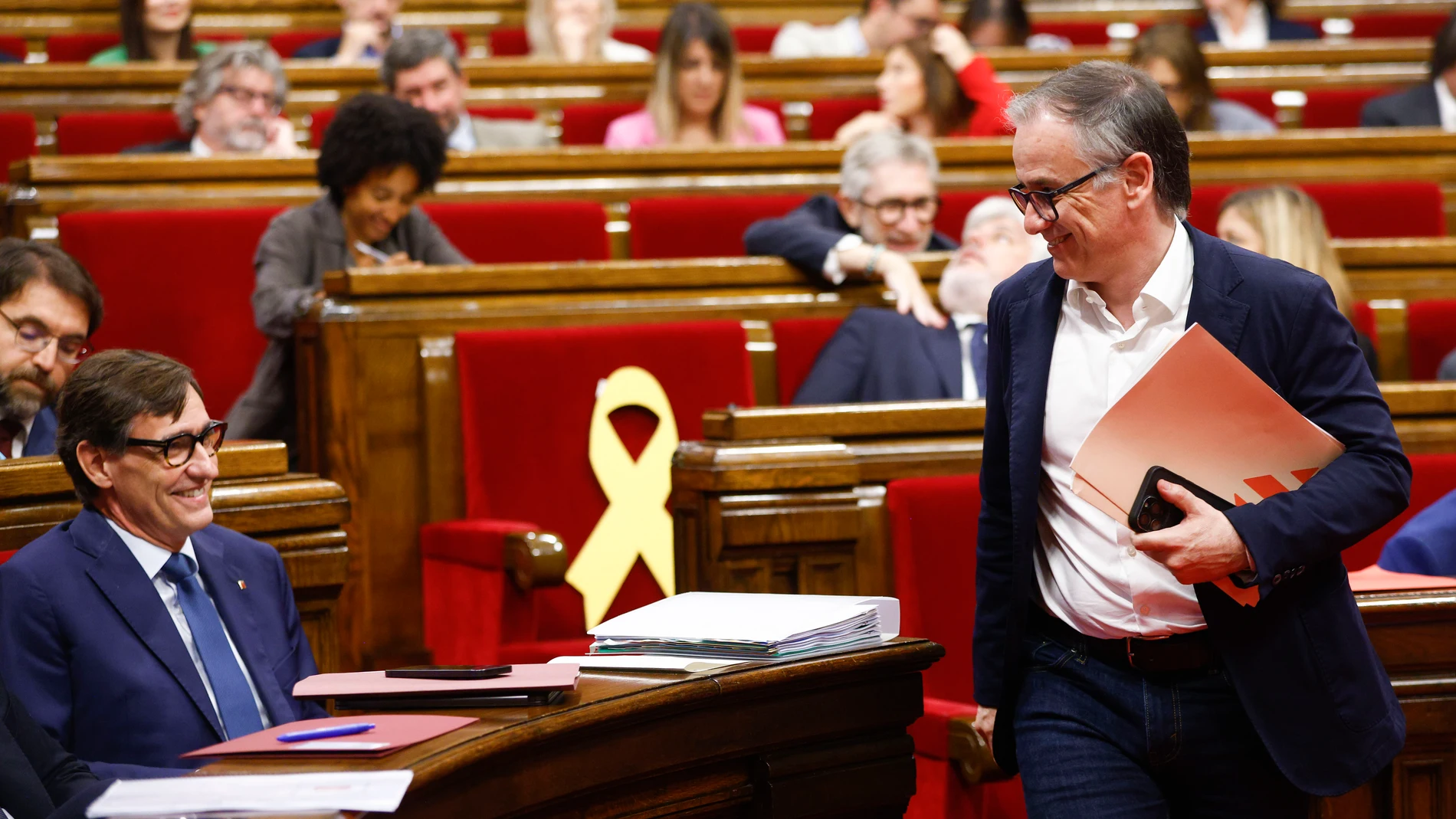 GRAFCAT2923. BARCELONA, 08/10/2025.- El presidente del grupo parlamentario de ERC, Josep Maria Bovè (d), saluda al presidente de la Generalitat, Salvador Illa, durante la segunda jornada del debate de política general, en la que el presidente catalán, Salvador Illa, mide el estado de sus relaciones con sus dos socios de investidura, ERC y Comuns, y con el resto de grupos parlamentarios de la oposición. EFE/Quique García