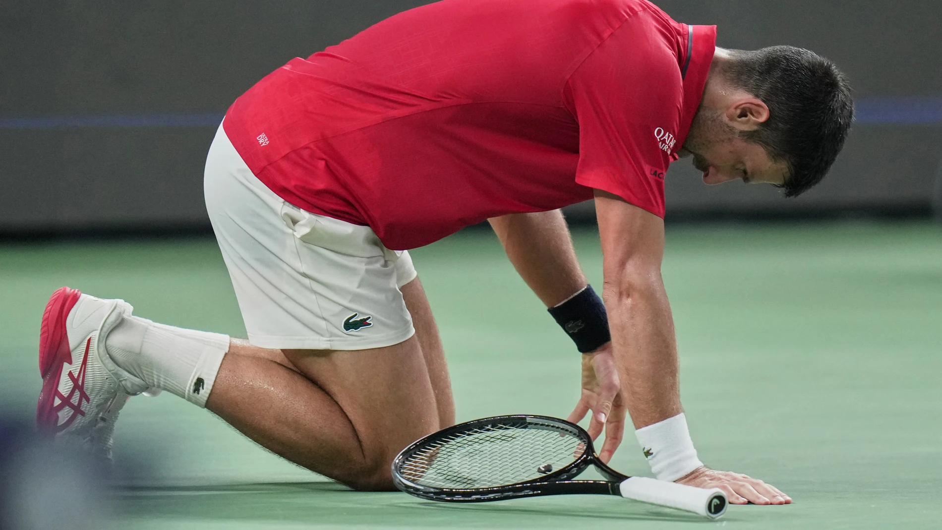 Novak Djokovic of Serbia knees on the court during their men's singles semifinal match against Valentin Vacherot of Monaco, at the Shanghai Masters tennis tournament at Qizhong Forest Sports City Tennis Center, in Shanghai, China, Saturday, Oct. 11, 2025. (AP Photo/Andy Wong)