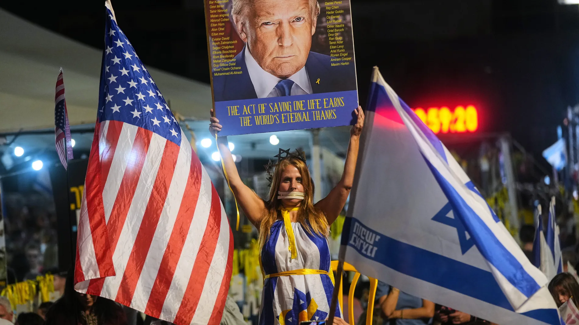 A woman holds a sign with an image of the U.S. President Donald Trump during a rally in support of hostages kidnapped by Hamas at a plaza known as hostages square, in Tel Aviv, Israel, Saturday, Oct. 11, 2025, ahead of the expected release of the hostages held in the Gaza Strip. (AP Photo/Francisco Seco)