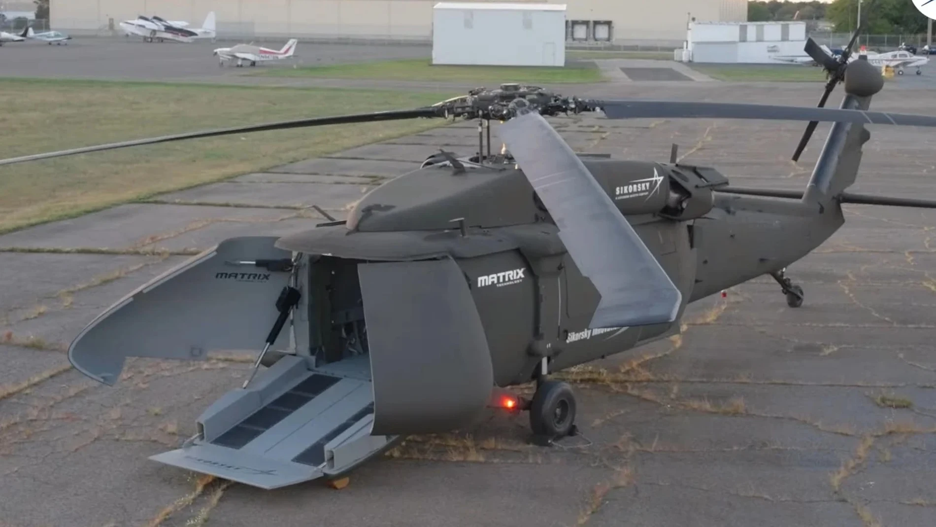 Helicóptero posado sobre el suelo con su parte delantera abierta
