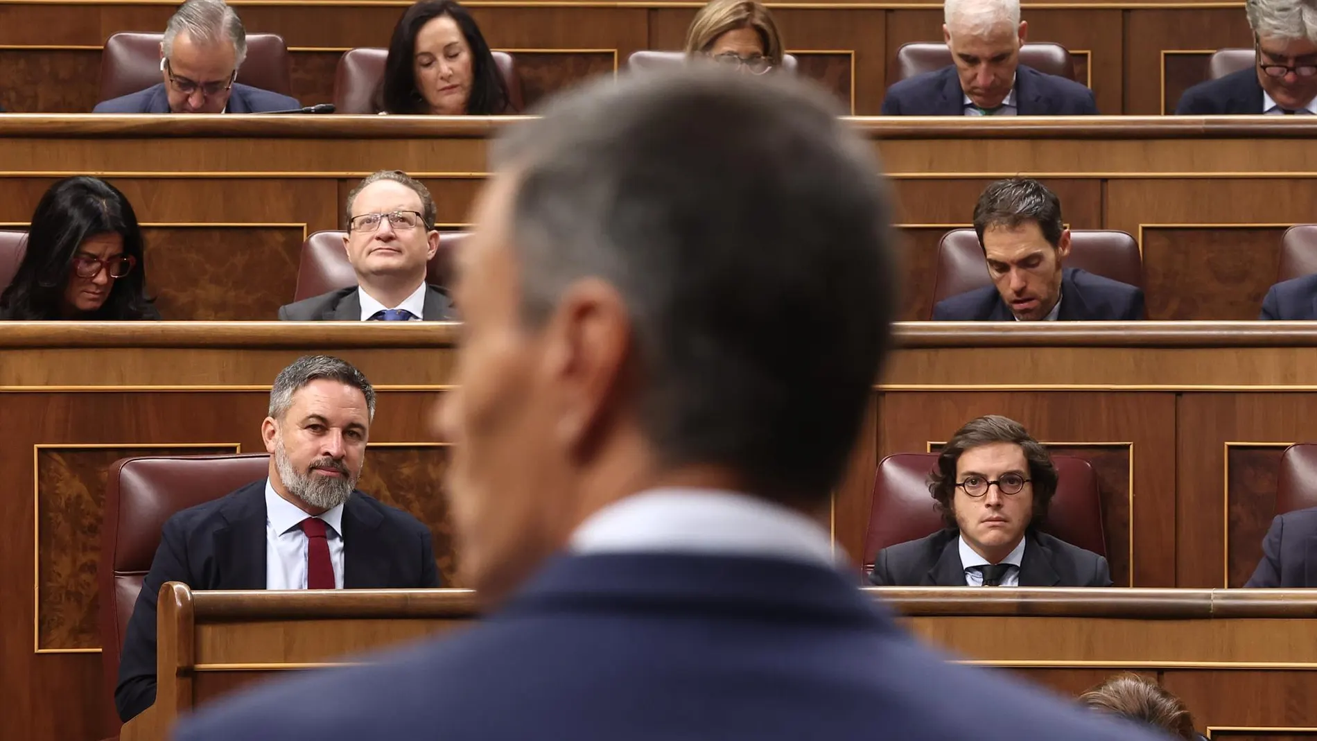 El líder de Vox, Santiago Abascal, escucha al presidente del Gobierno