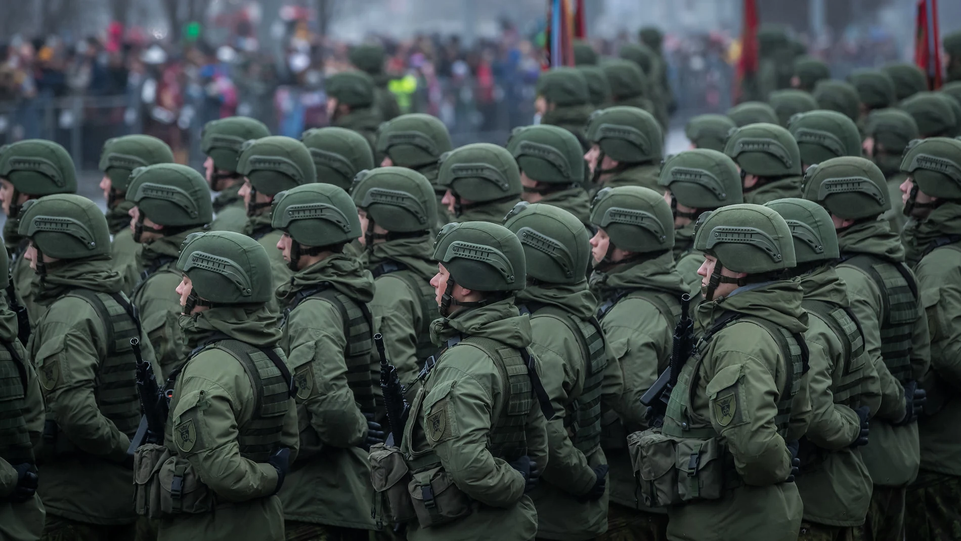 Soldados con uniforme verde oscuro en una parada militar con los brazos cruzados hacia la espalda