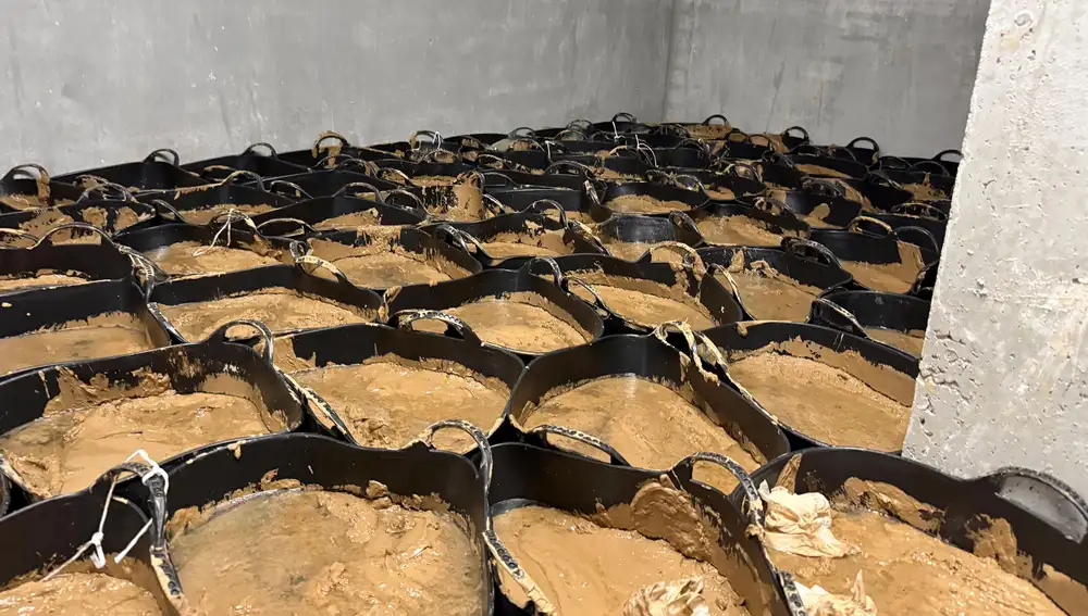 Cubos de lodo retirados que se acumulan en el garaje