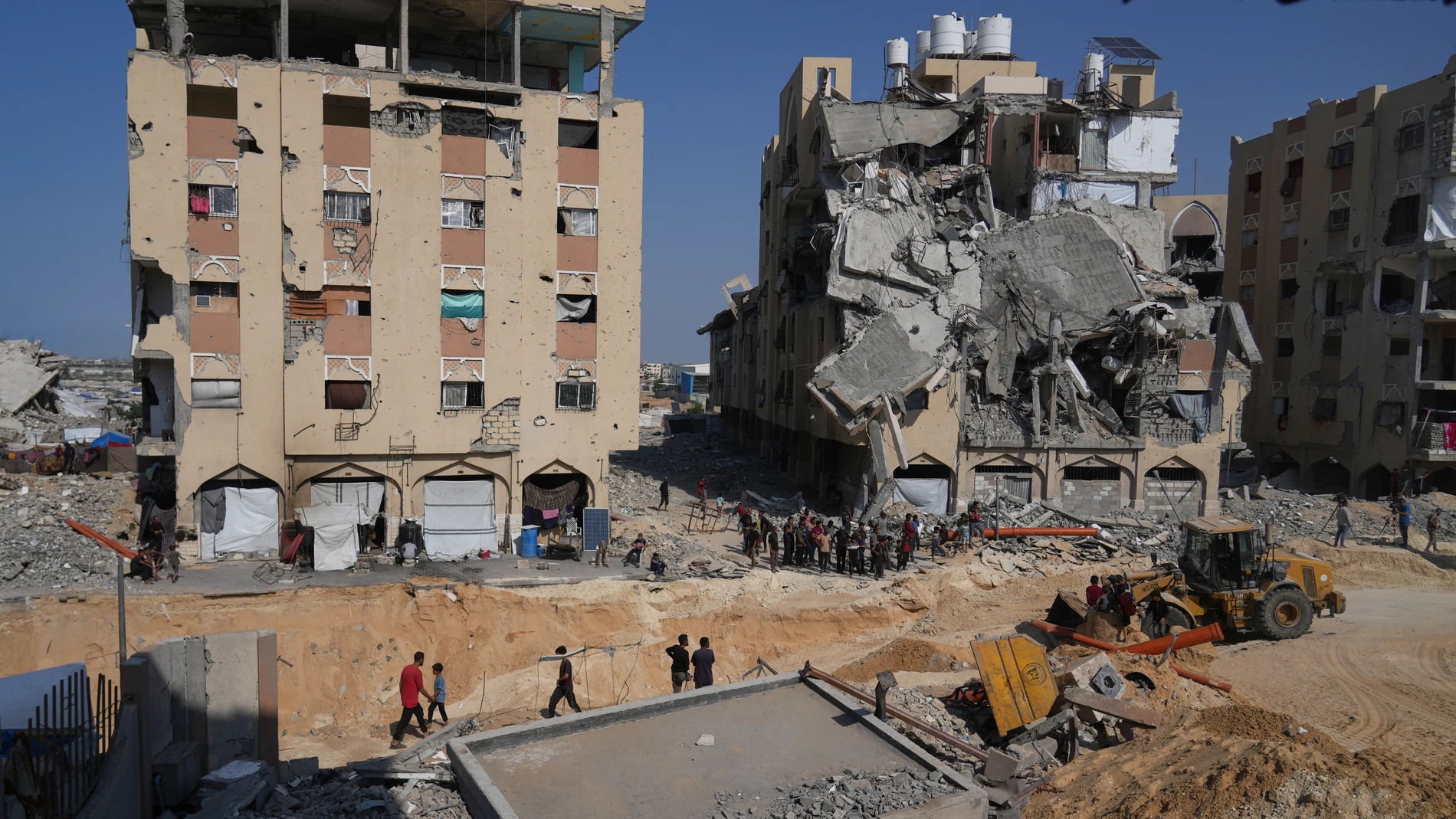 Members of the Hamas militant group work on searching for bodies of the hostages in an area in Hamad City, Khan Younis, in the southern Gaza Strip, Friday, Oct. 17, 2025. (AP Photo/Abdel Kareem Hana)