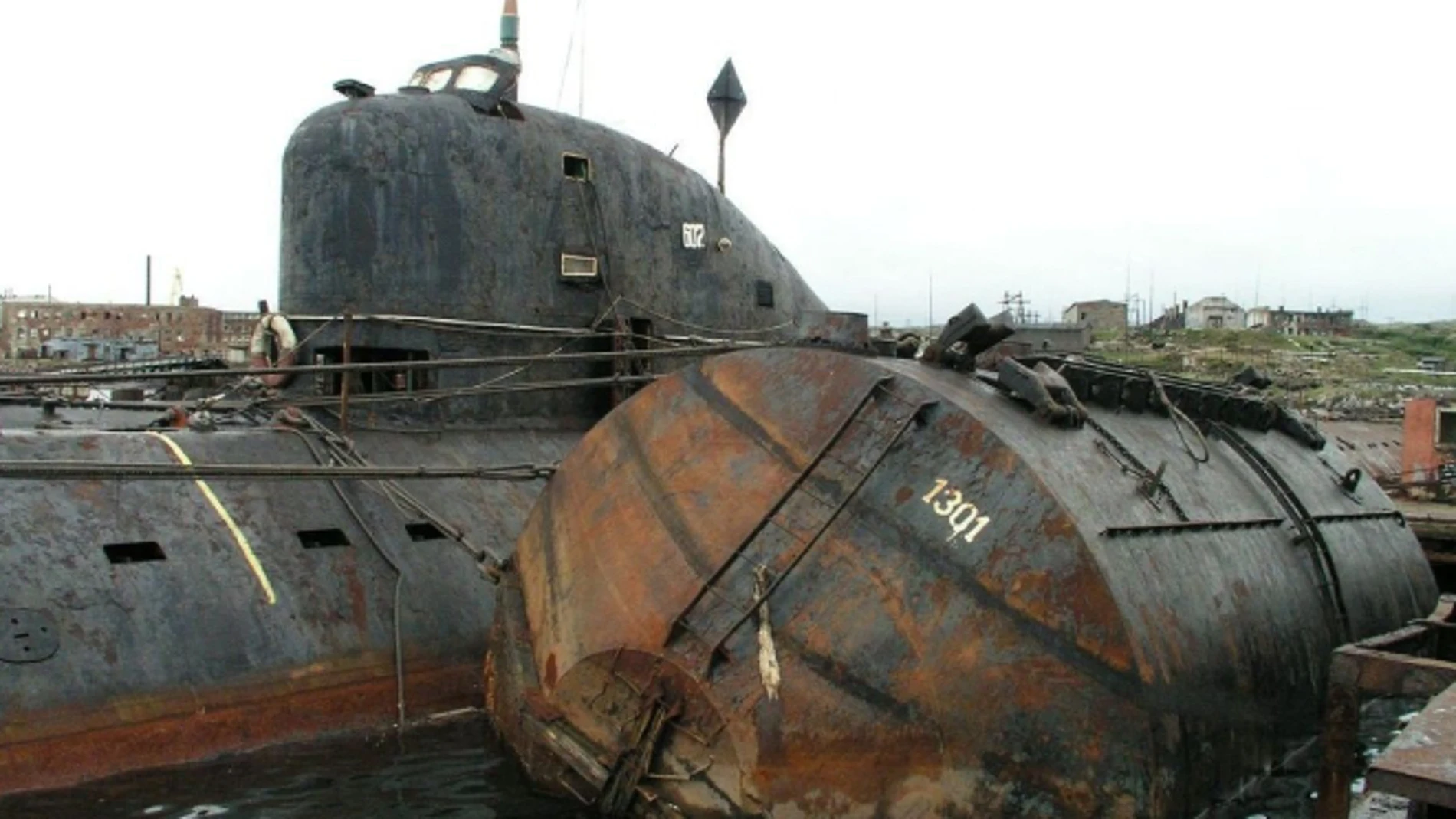 Detalle del K-159 y uno de los tanques vacíos que se usaron como pontones para que no se hundiera.