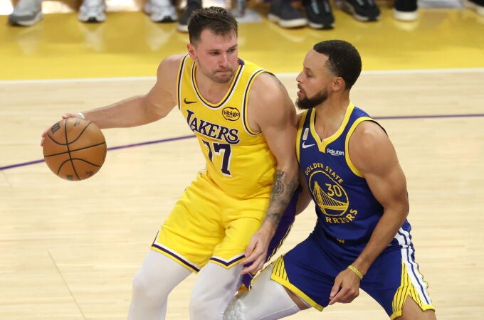 Stephen Curry defiende a Luka Doncic
