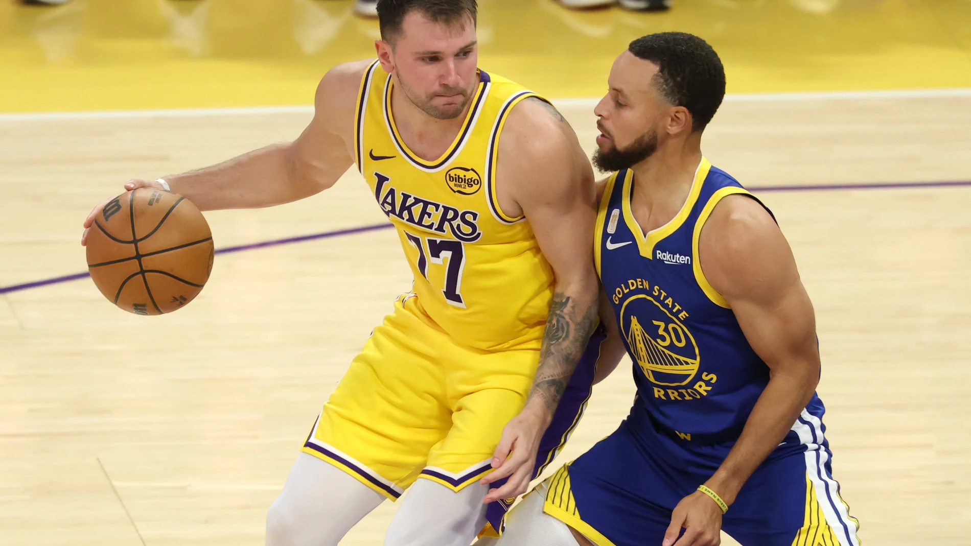 Stephen Curry defiende a Luka Doncic