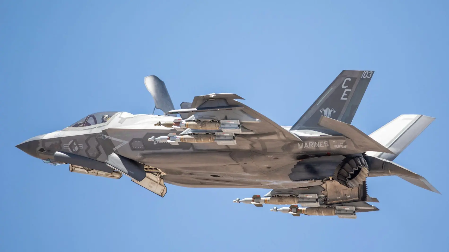 Avión de combate volando con todo su armamento (misiles) expuesto