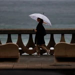 Una mujer camina por el paseo marítimo de A Coruña